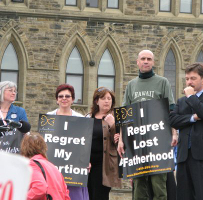 David holding abortion sign, Silent No More, Canadian Parliament